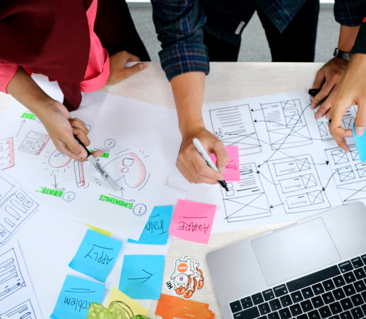 Two people collaborating on paper at a table during an ideation session