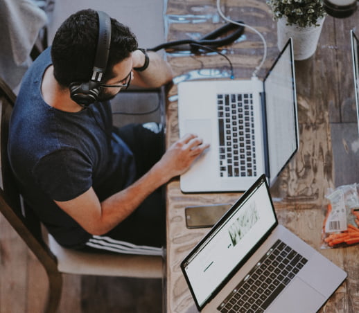 Person wearing headphones working on a laptop