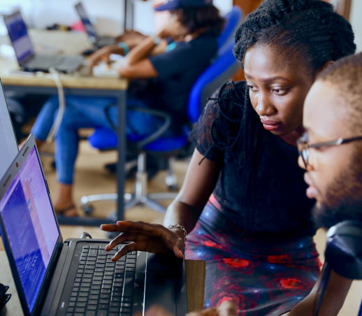 Two people reviewing information on a laptop