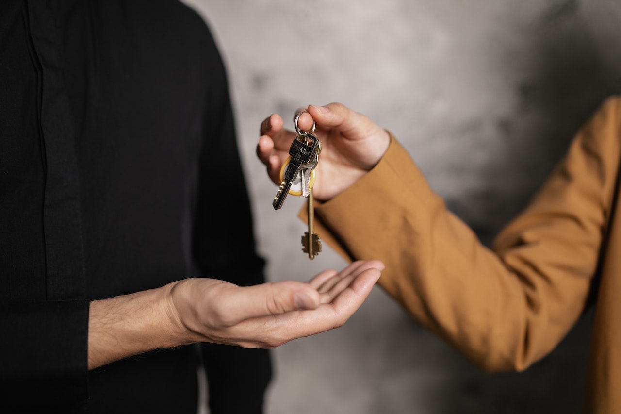 A person handing a ring of keys to another person