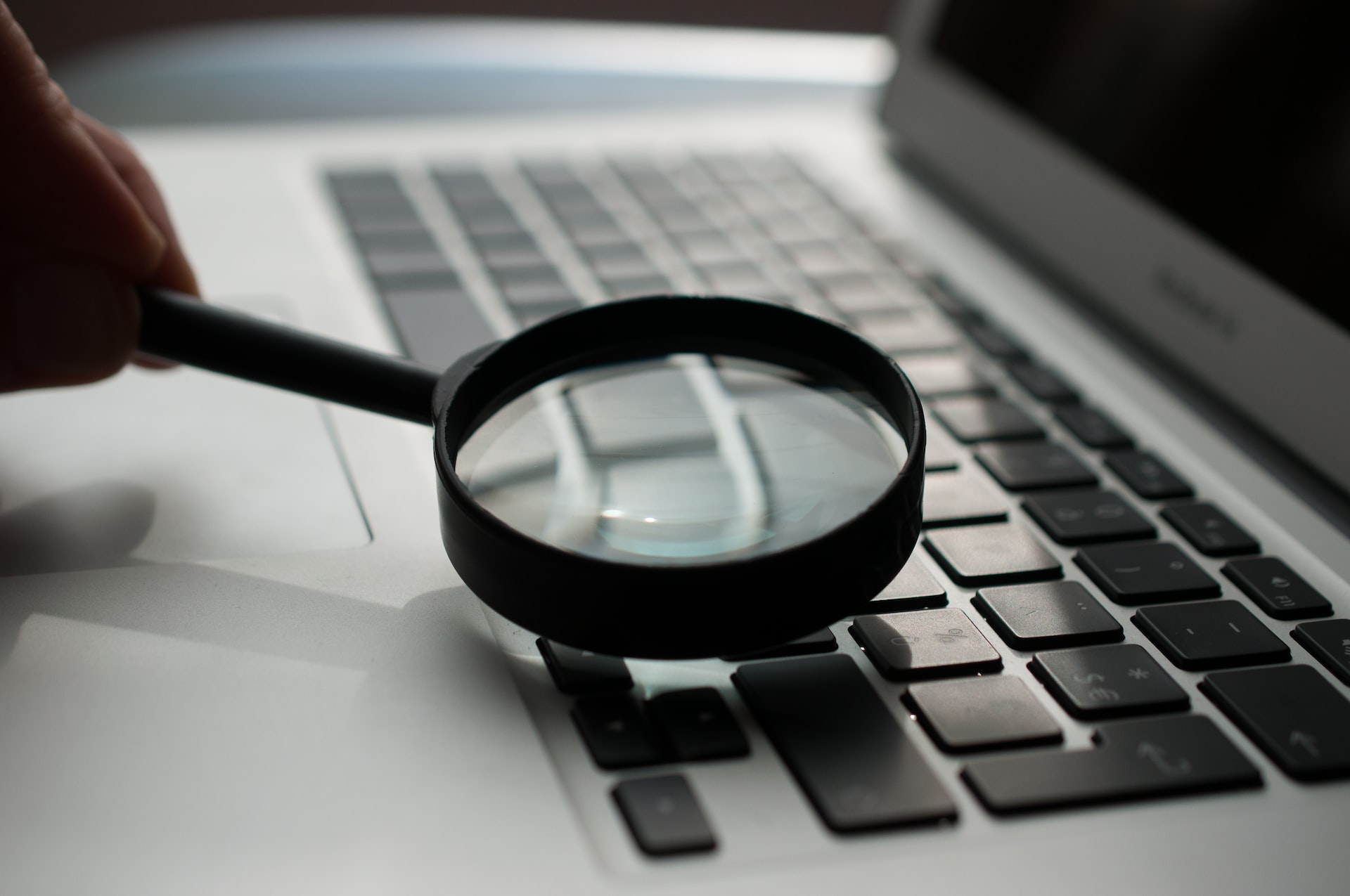 A magnifying glass focused on a laptop keyboard