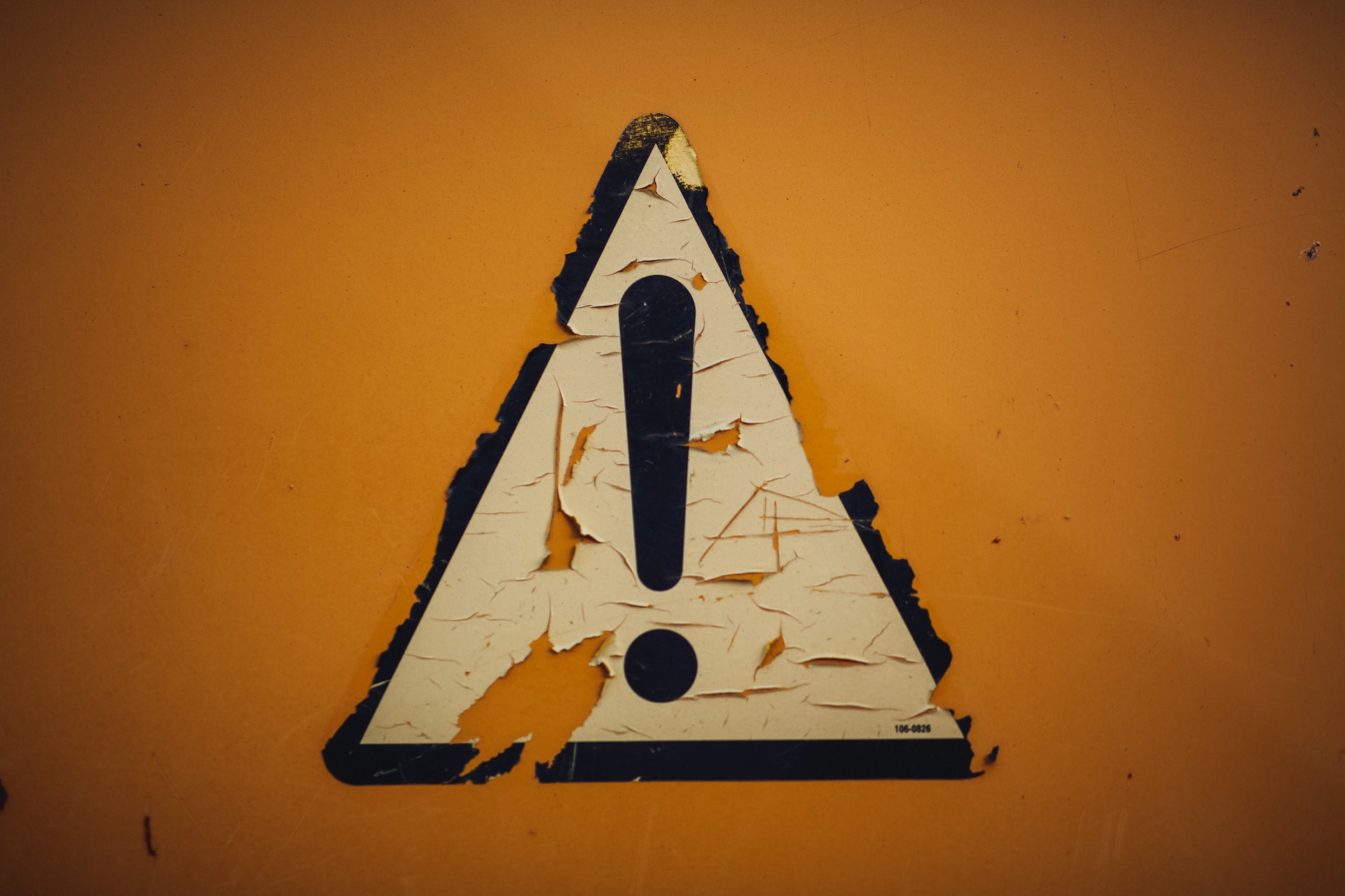 Yellow warning sign with paint peeling off
