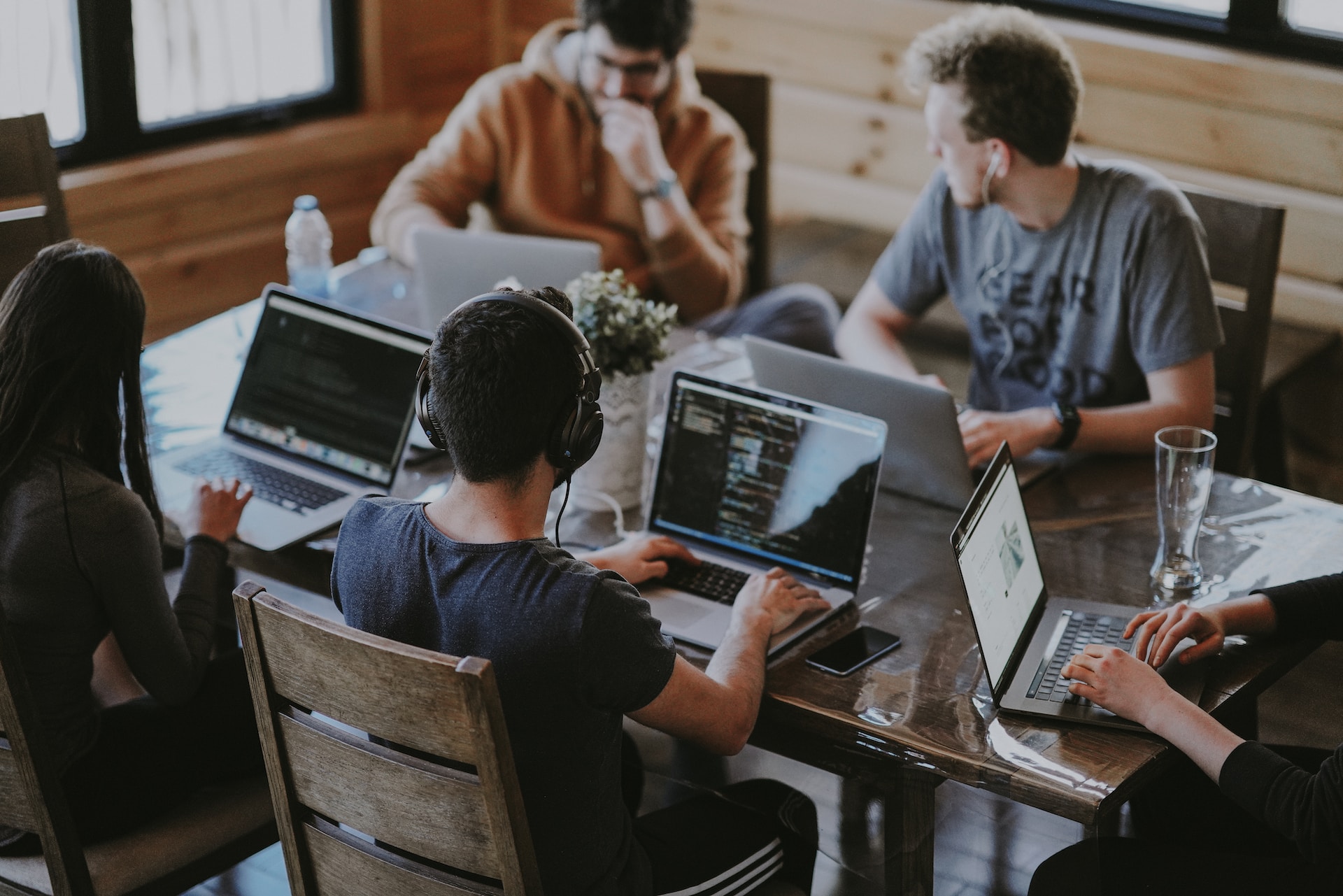 Software developers sitting around a table with their laptops