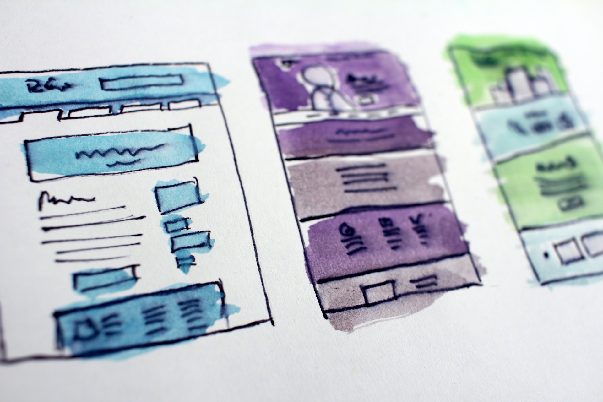 Hand-drawn and colored wireframes on a desk