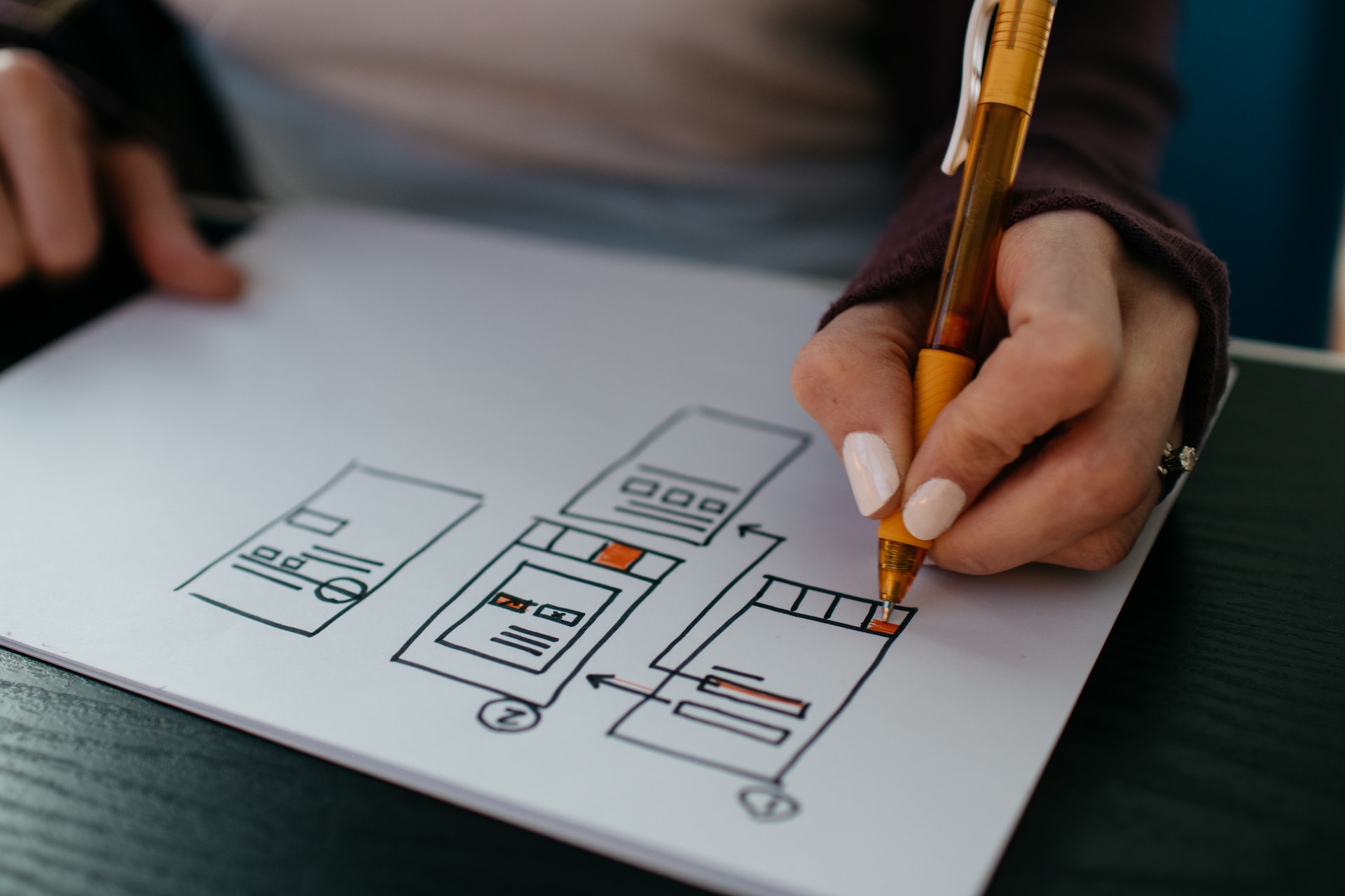 Person drawing mobile app wireframes on a piece of paper